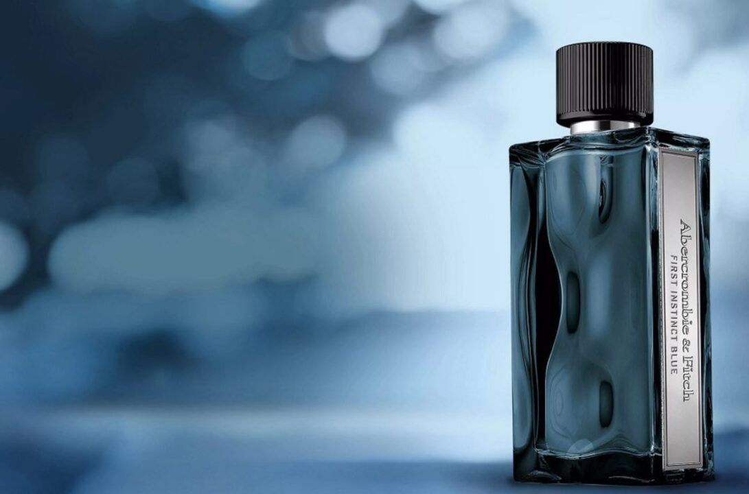 Sleek bottle of cologne on blue background exuding sophistication and elegance.