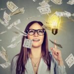 Innovative woman sparks financial success with glowing idea, money swirling around her.
