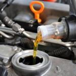 Adding golden engine oil to car engine for routine maintenance in clean, controlled setting.