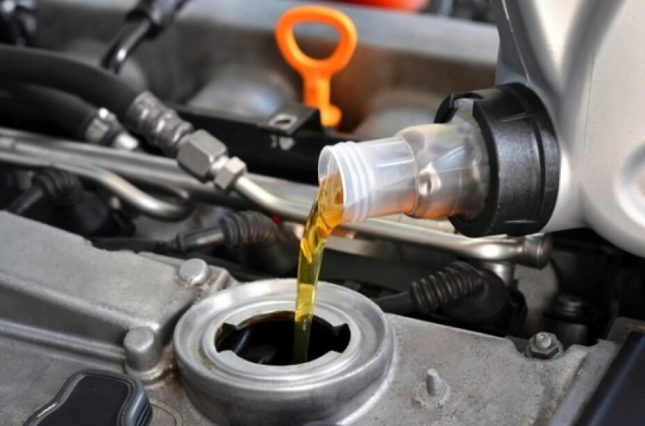 Engine oil being poured into a car's engine through a funnel.