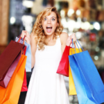 Excited woman shopping with colorful bags in mall.