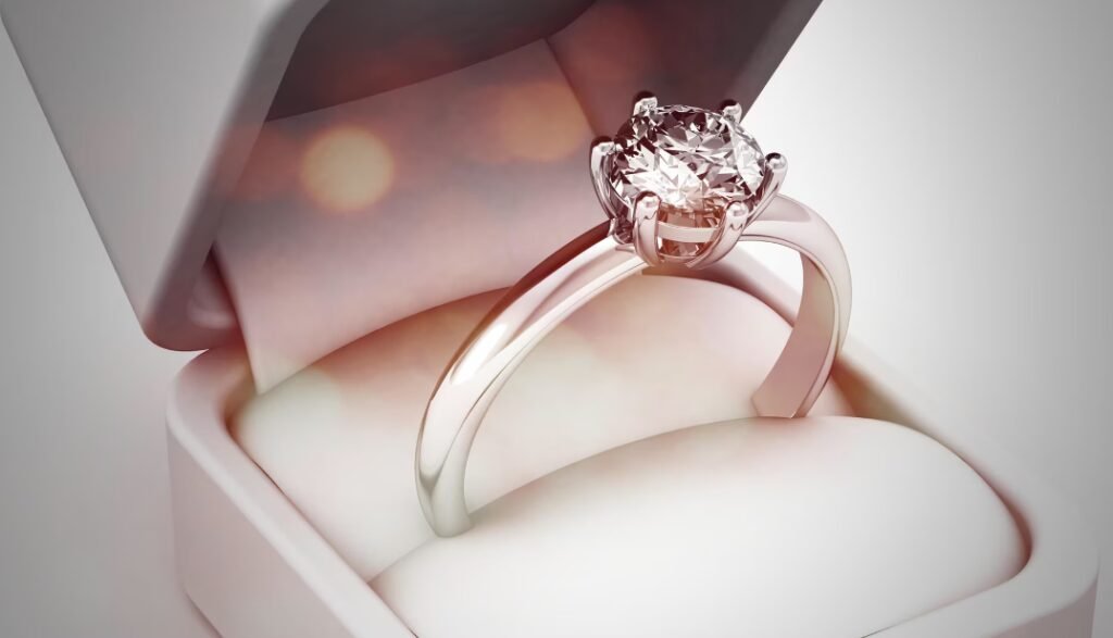 A solitaire diamond engagement ring displayed in an open white box with a soft velvet interior.