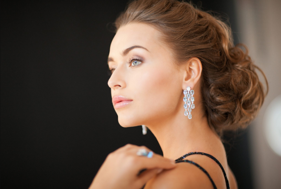 Elegant woman with sparkling chandelier earrings in serene profile.