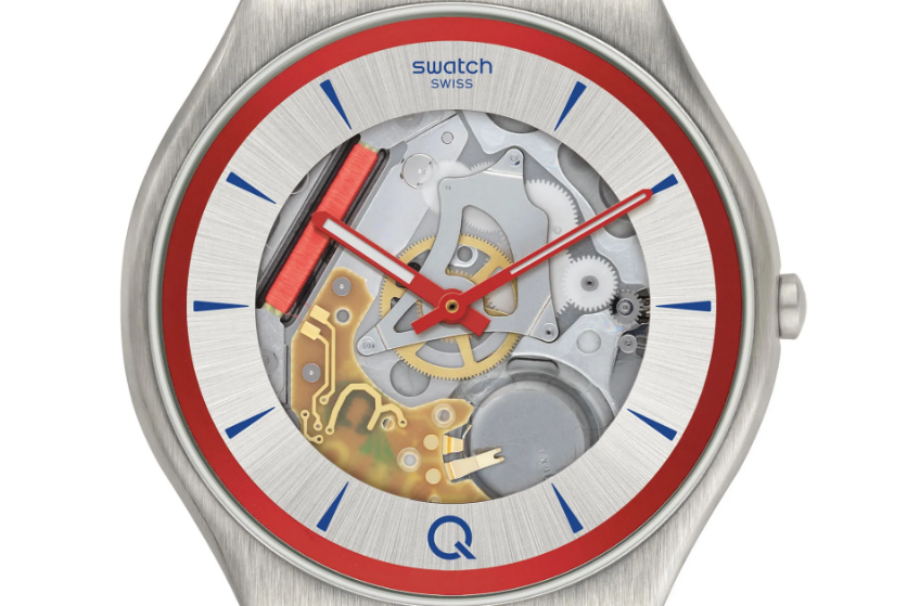 A Swatch wristwatch featuring an exposed mechanical movement with silver, gold, and red components, set within a round silver-tone case with a red and blue accented dial, red watch hands, and the Swatch logo at the top.