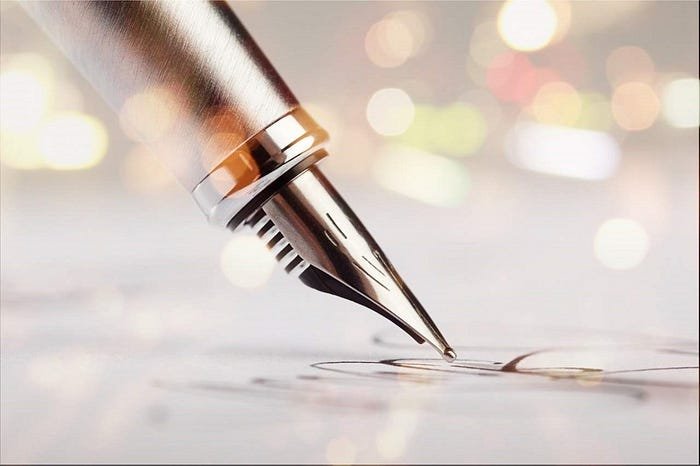 Elegant fountain pen on fine paper in warm, bokeh-lit setting.