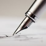 Silver fountain pen writing on paper, capturing elegance and precision in traditional writing.