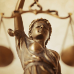 Golden Lady Justice statue with blindfold and scales, symbolizing impartiality and balance in law.