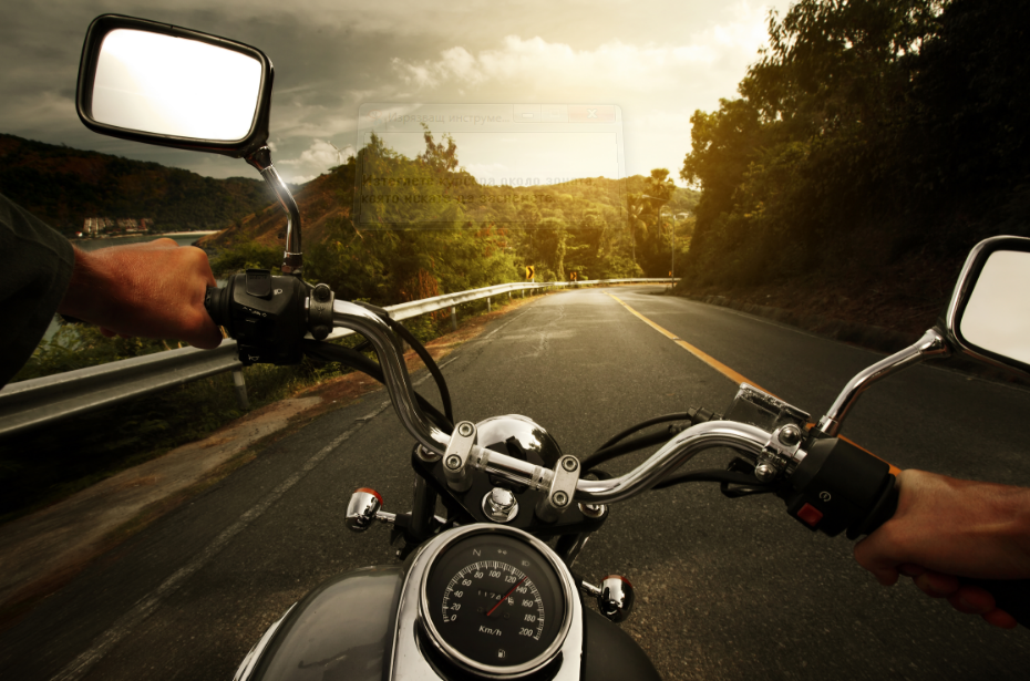 Motorcycle rider on scenic road at sunset, surrounded by lush countryside and golden sky.