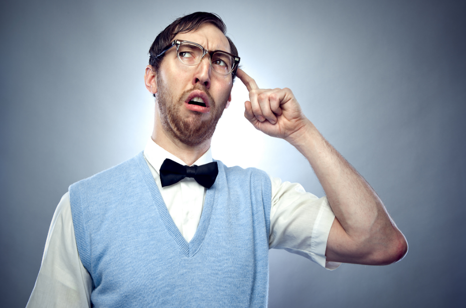Quirky man in glasses and bow tie looking puzzled against gradient grey background.