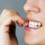 Close-up of person biting nail in thoughtful gesture, displaying signs of anxiety or nervousness.