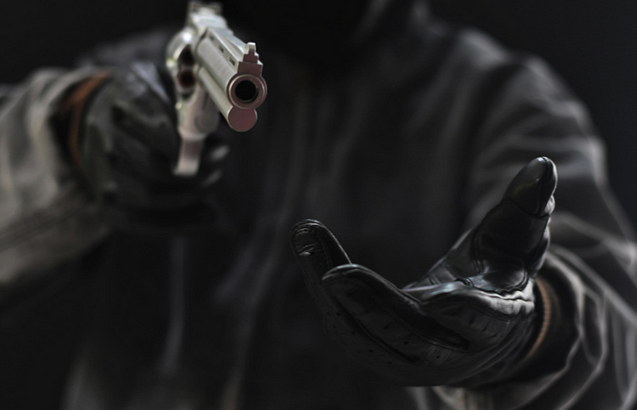 Dark figure pointing handgun with outstretched hand, creating tense atmosphere.