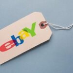 Beige eBay logo price tag on blue background for online sales and commerce.