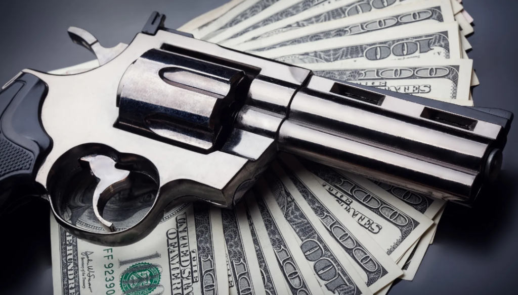 A revolver lying on top of a spread of US 100-dollar bills.