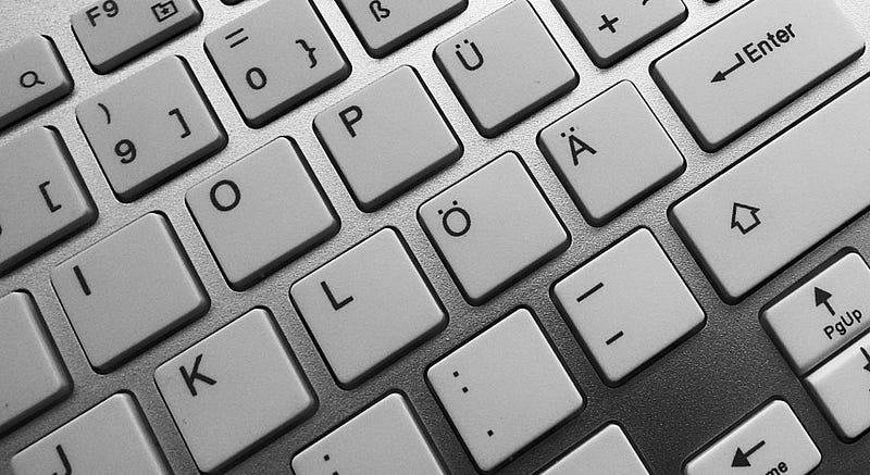 Close-up of a computer keyboard with keys showing Scandinavian character layout in monochrome.