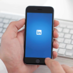 Modern professional workspace with LinkedIn app, green plant, and sleek technology.