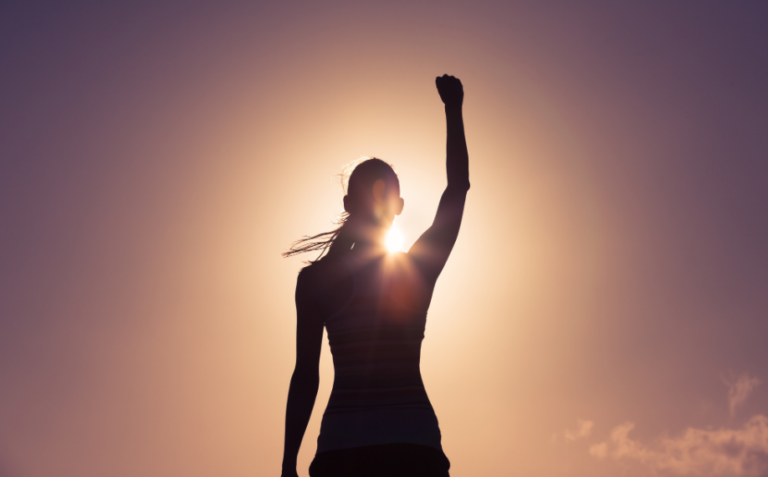 Triumphant silhouette against vibrant sunset sky, symbolizing success and inspiration.