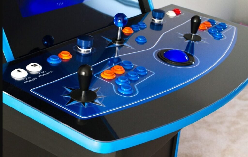 Close-up of an arcade game console with two joystick controls, multi-colored buttons, and player start buttons on a blue and black panel.