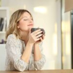 Woman enjoying hot drink in peaceful setting, savoring the moment of relaxation.