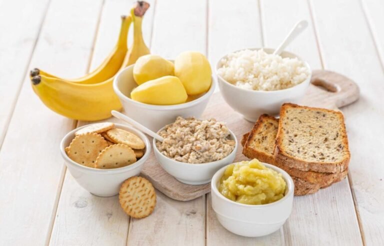 Assorted carb-rich foods on wooden table for energy-packed meals.