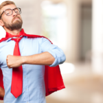 Confident hero in blue shirt with red cape posing heroically.