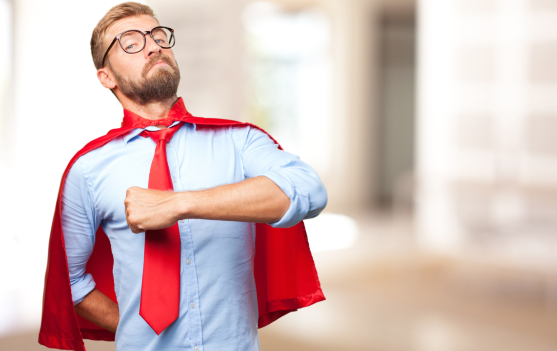 Confident hero in blue shirt with red cape posing heroically.