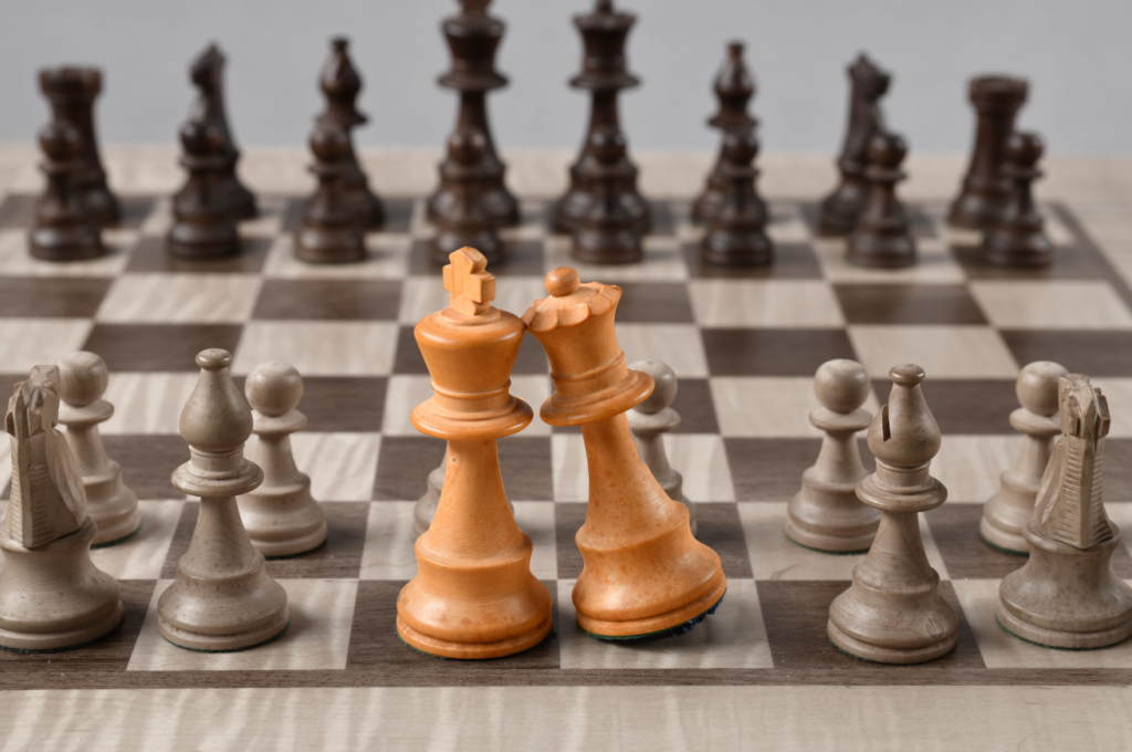 A chessboard with chess pieces in mid-game, highlighting two kings standing side by side on the board.