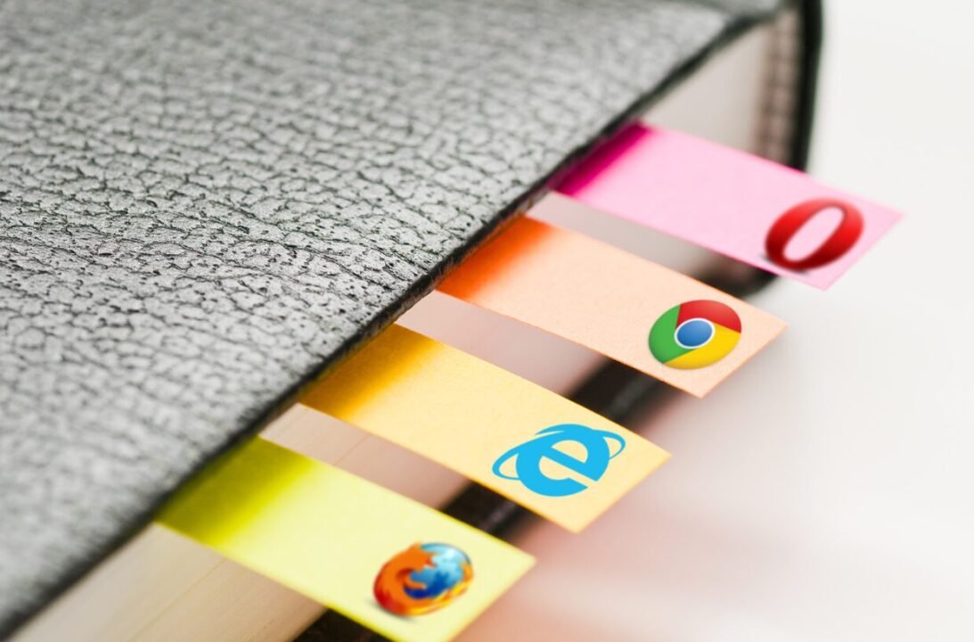 Close-up view of colorful browser logo tabs protruding from a textured black notebook.