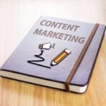 Content Marketing Book with Megaphone and Pencil Illustration on Wooden Surface