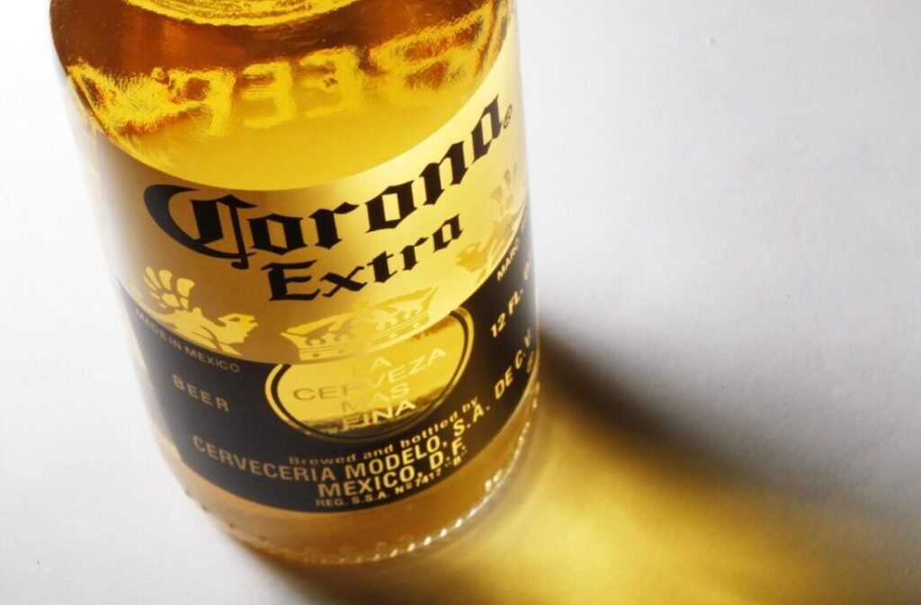 Close-up of a Corona Extra beer bottle label showing the logo and text, lit with a warm light.