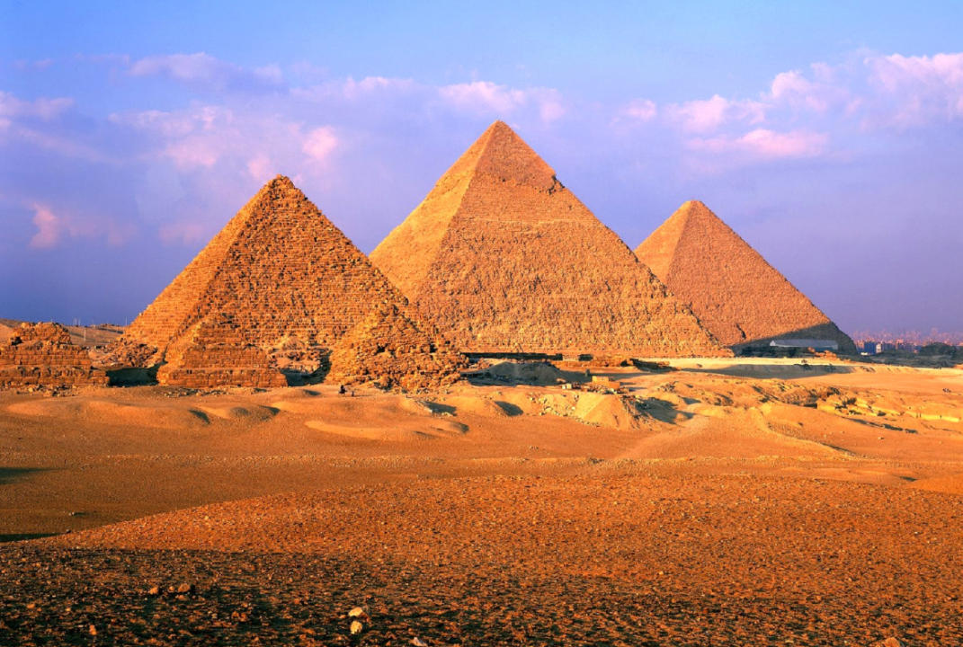 Sunset view of iconic Egyptian Pyramids in Giza, showcasing ancient engineering and civilization.