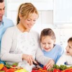 Family cooking together in a cheerful kitchen scene with fresh vegetables, warm atmosphere.