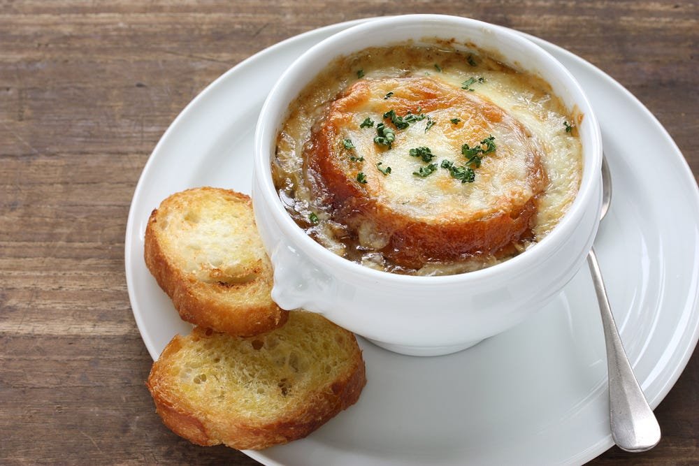 Delicious French Onion Soup with Melted Cheese, Herbs, and Toasted Baguette.