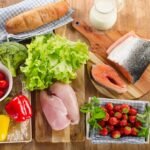 Fresh variety of healthy foods on wooden surface for balanced diet and meal prep.