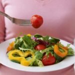 Fresh vegetable salad with cherry tomatoes, bell peppers, and greens for healthy eating.