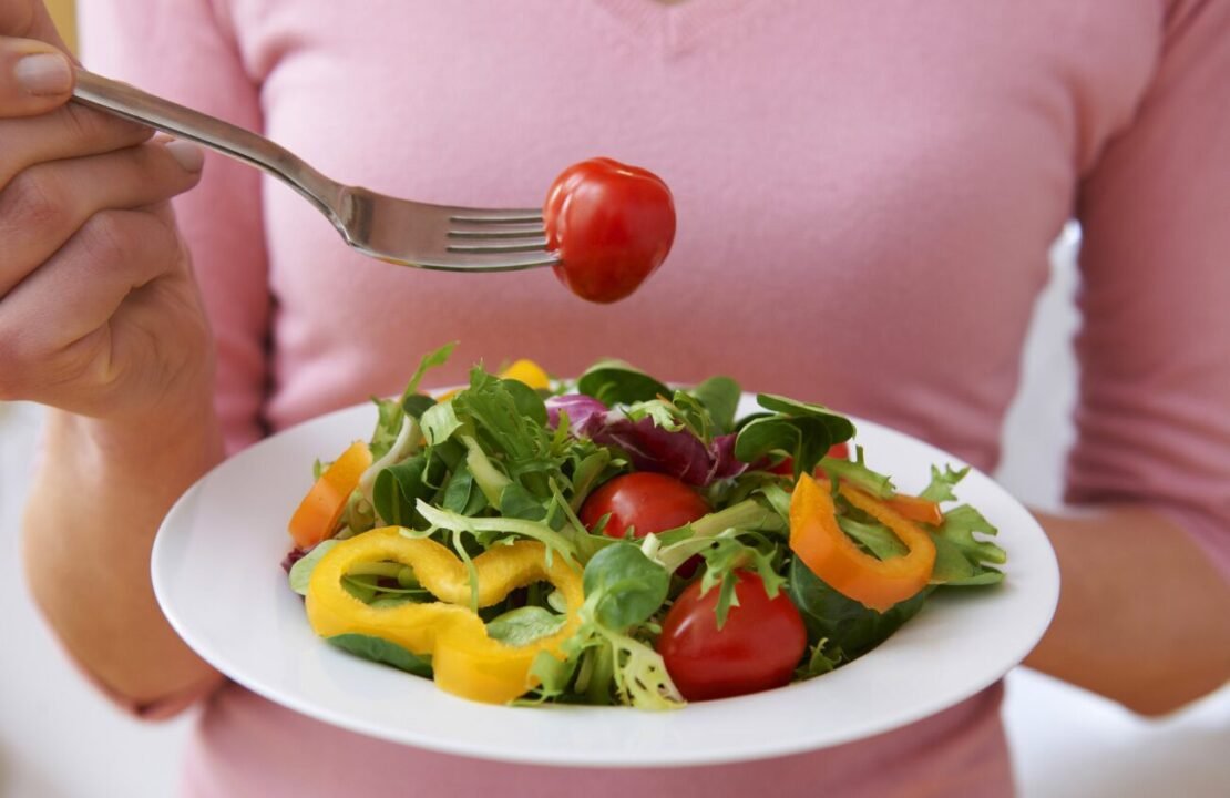 Fresh vegetable salad with cherry tomatoes, bell peppers, and greens for healthy eating.