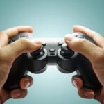 Hands-on gameplay with modern controller, immersive experience against blue background.