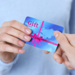 Hands exchanging blue gift card symbolizing gesture of giving and receiving in a professional setting.