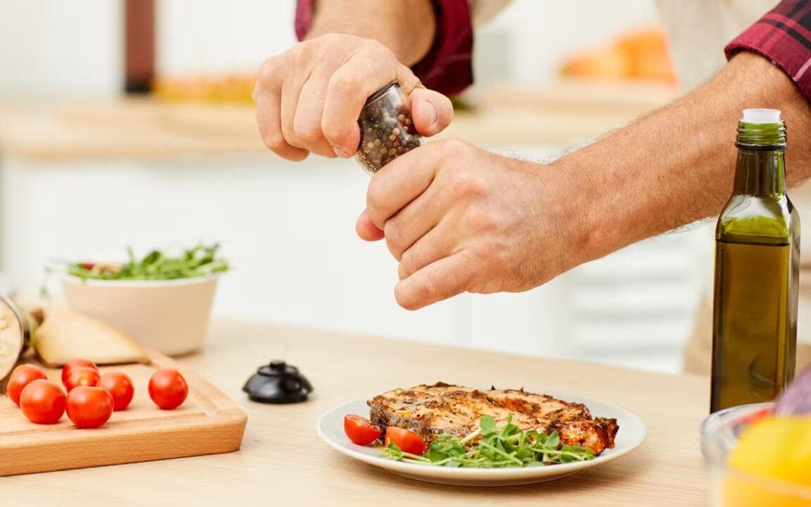 Grilled chicken with fresh veggies, cherry tomatoes, and olive oil on kitchen counter.