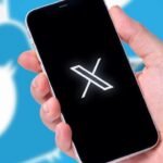 Smartphone displaying white X symbol against Twitter background, hinting at possible disruption.