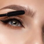 Elegant eye makeup: grooming and shaping eyebrows with mascara for a polished look.