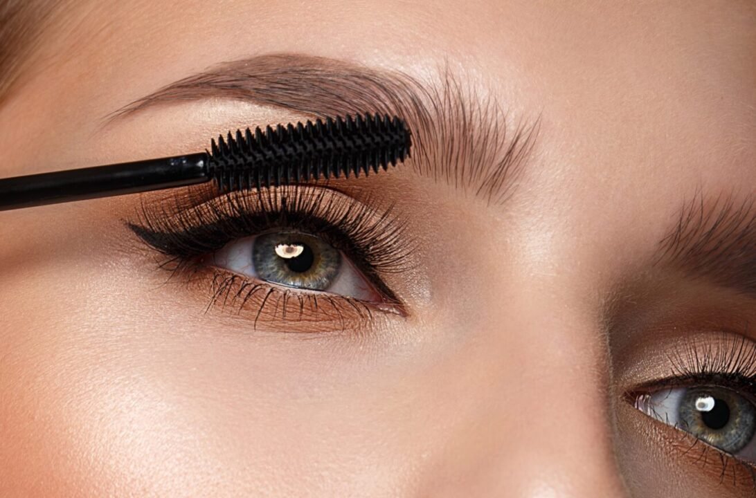Elegant eye makeup: grooming and shaping eyebrows with mascara for a polished look.