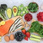 Assorted healthy foods display vibrant colors and nutrients on light background.