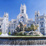 Historical landmark in Madrid: Majestic palace with lion fountain under sunny sky.