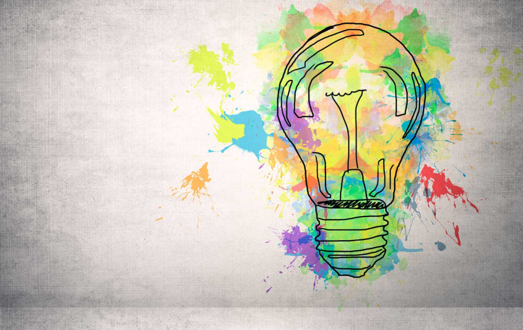 Vibrant light bulb surrounded by colorful watercolor splashes on textured gray background.