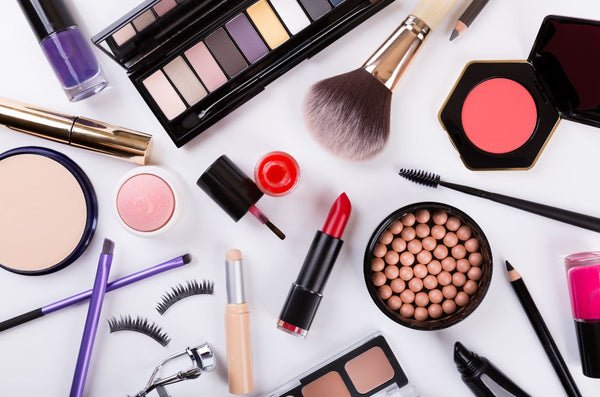 Assorted makeup essentials on white background for beauty routine.