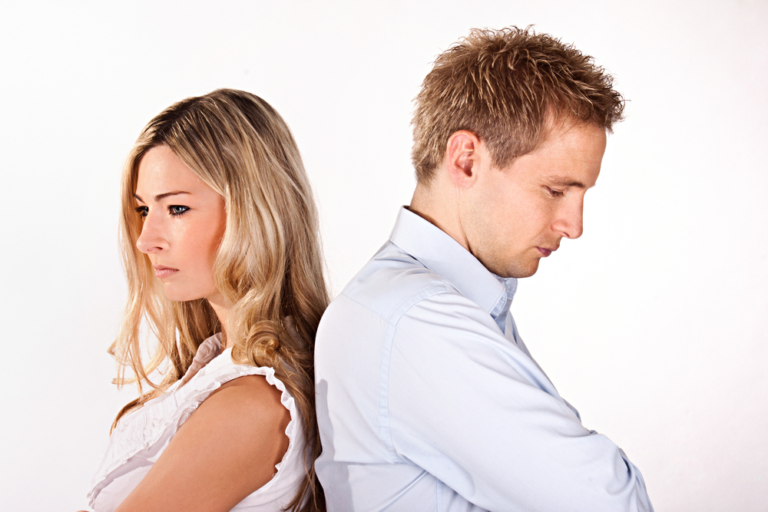 Tense standoff between serious man and woman on white background.