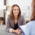 Professional woman smiling in office meeting, showcasing positive business interaction.