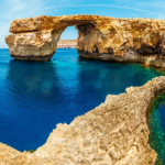 Breathtaking limestone arch over crystal blue sea: majestic coastal beauty.