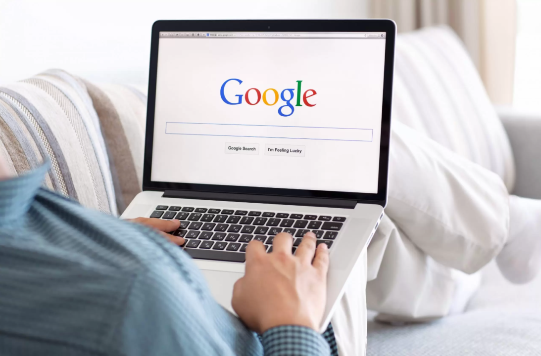 Person using Google Search on laptop in cozy home environment with natural light.