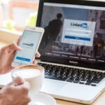 Networking on LinkedIn during coffee break at work - modern professional multitasking.